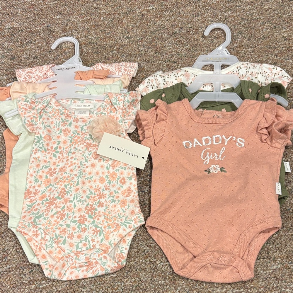 7 adorable ruffled onesies. 4 are Laura Ashley and 3 are Tahari Baby. NWT. Cute